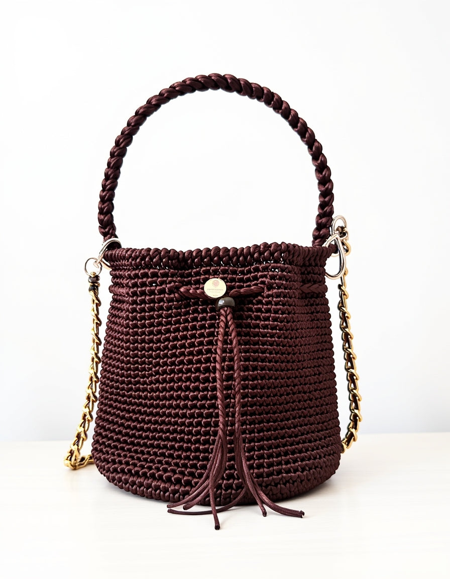 Diseño exclusivo Domenechsa: mochila tejida en tono vino con detalles dorados.