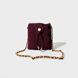 Mochila artesanal color borgoña con cadena dorada elegante.