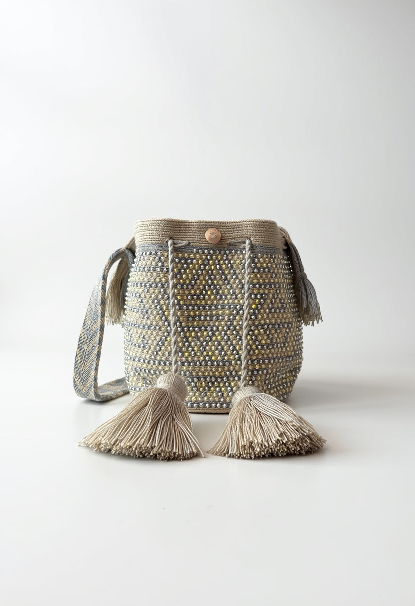 Bolso mochila artesanal con pompones decorativos, ideal para uso casual o elegante.