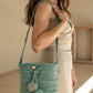 Bolso tejido a mano color agua marina con correa ancha calada.