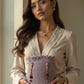 Bolso artesanal color lavanda con detalle de cuentas negras y burdeos.