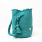 Mochila Domenechsa color turquesa vibrante, diseño artesanal moderno con borlas decorativas y acabado elegante
