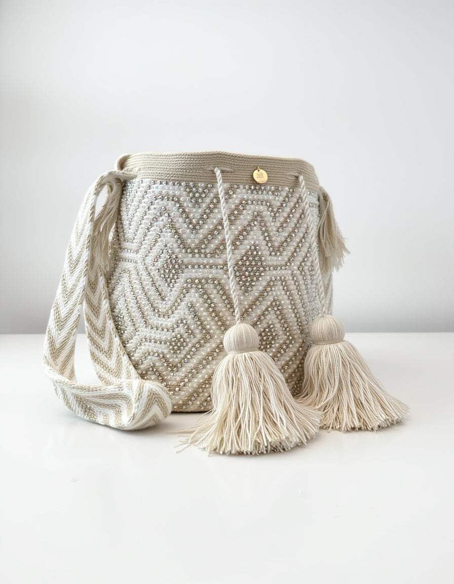 Bolso artesanal en color crema con diseño geométrico y borlas XL.