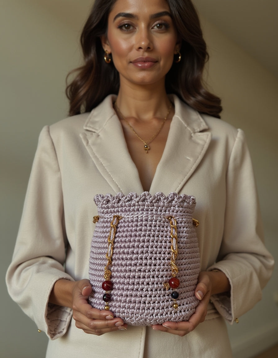 Mochila pequeña en tono lavanda con detalles de lujo en dorado y piedras.