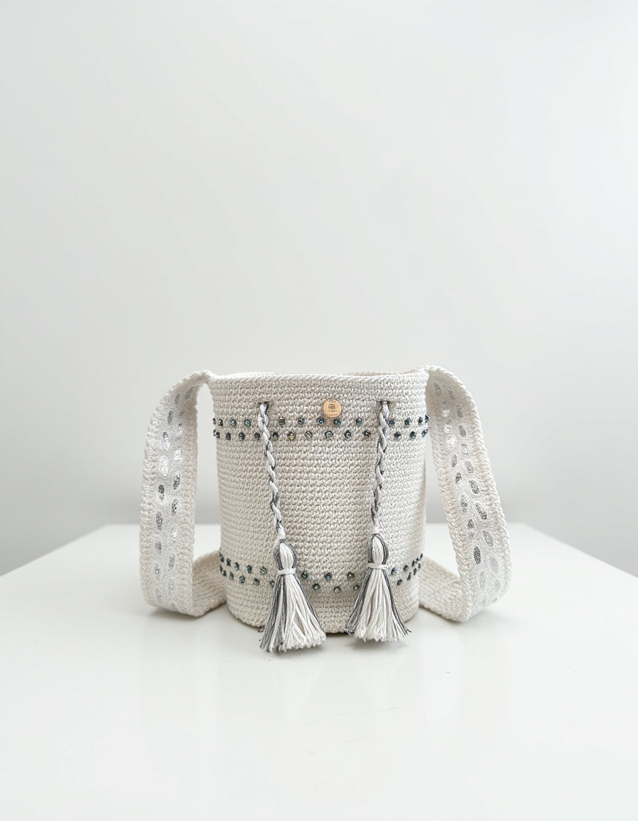 Mochila pequeña en color perla con strap tejido y detalles de lujo, hecha artesanalmente.