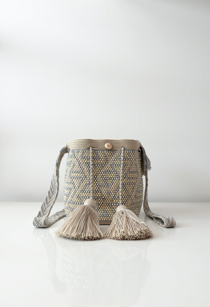 Mochila Aurora Dorada tejida a mano con diseño geométrico en tonos dorado y beige.