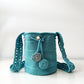 Mochila artesanal en color celeste brillante con detalles en relieve.