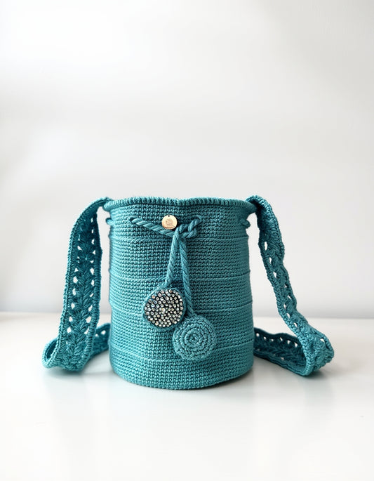 Mochila artesanal en color celeste brillante con detalles en relieve.