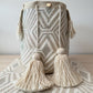 Diseño exclusivo en beige claro con textura de zigzag y borlas decorativas.
