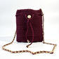 Mochila de lujo color vino con detalles dorados y diseño artesanal.
