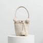 Bolso blanco con asa firme y perlas brillantes, hecho a mano por artesanos de Domenechsa.