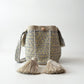 Bolso mochila artesanal con pompones decorativos, ideal para uso casual o elegante.
