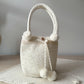Bolso artesanal en tono blanco con textura fina y perlas de adorno, hecho a mano con estilo.


