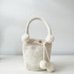 Mochila artesanal blanca de Domenechsa, decorada con perlas y pompones tejidos a mano