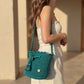 Bolso artesanal en tono turquesa esmeralda, tejido tipo crochet con detalle de etiqueta dorada de Domenechsa